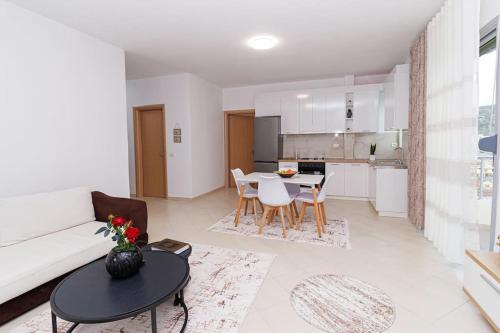 a living room with a white couch and a table at Stylish City Apartment in Vlorë