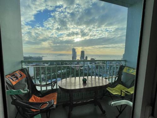 a balcony with a table and chairs and a view of the city at Green Residences Stays by PBYY in Manila