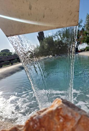 a fountain with water pouring into a pool of water at Giardini Penelope Resort e Spa in Ciampino