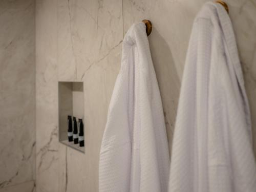 a bathroom with white towels hanging on a wall at Salamanca Suites in Hobart