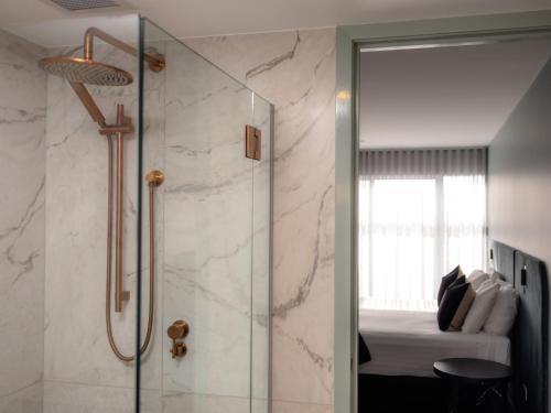 a bathroom with a shower and a bedroom with a bed at Salamanca Suites in Hobart