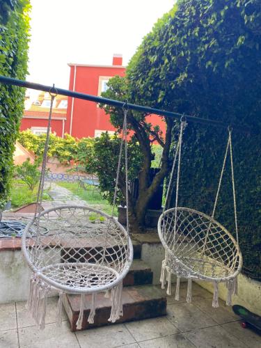 two swinging chairs in a garden with a staircase at SEA Villa Rosa Charm Seaside and Garden in Porto