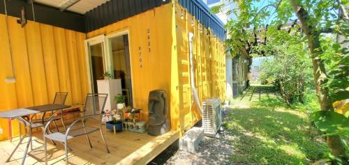 a yellow house with a table and chairs on a deck at 宜蘭81 Boat輕旅 寵物友善 小團體包棟 獨棟villa in Jiaoxi