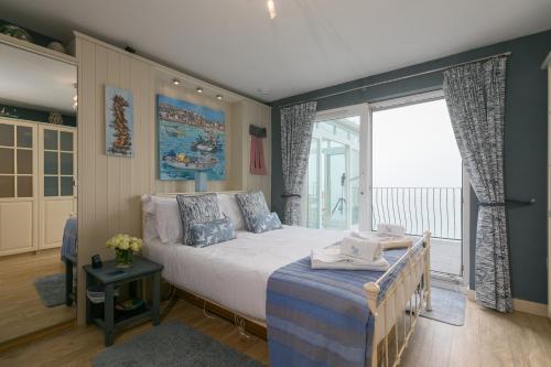 a bedroom with a bed and a large window at Huers Hide in Carbis Bay
