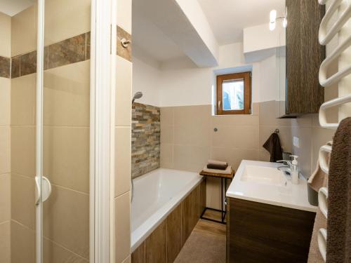 a bathroom with a bath tub and a sink at Ferienwohnung Frieda in Ellmau