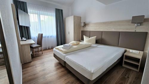 a bedroom with a large white bed and a desk at Riverhouse in Nordenham