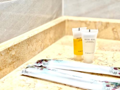 a bathroom counter with two toothbrushes and a bottle of sunscreen at STAR BAY Residence Sihanoukville - 400m to Sokha Beach in Sihanoukville