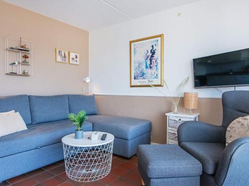 uma sala de estar com sofás azuis e uma televisão em 4 person holiday home in Fan em Fanø