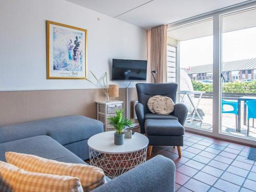 4 person holiday home in Fan في فانو: غرفة معيشة مع أريكة وكراسي وتلفزيون