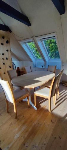 a table and chairs in a room with windows at Værelse med egen stue in Horsens