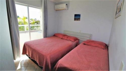 2 camas en una habitación con ventana en 1010 - Residencial Solar das Bromélias Apto 233 en Bombinhas