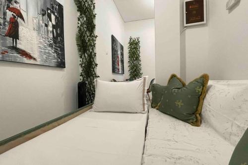 - un canapé blanc dans le salon avec des oreillers dans l'établissement Alfa home, à Athènes