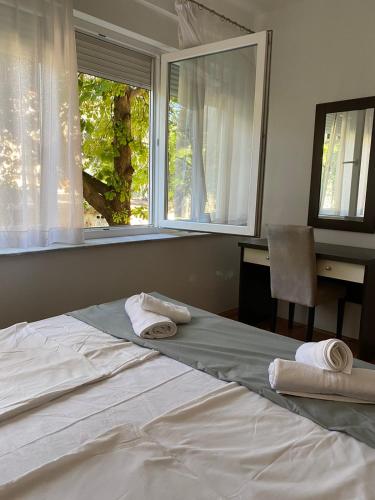 een slaapkamer met een groot bed en handdoeken bij Apartman Nika in Mostar