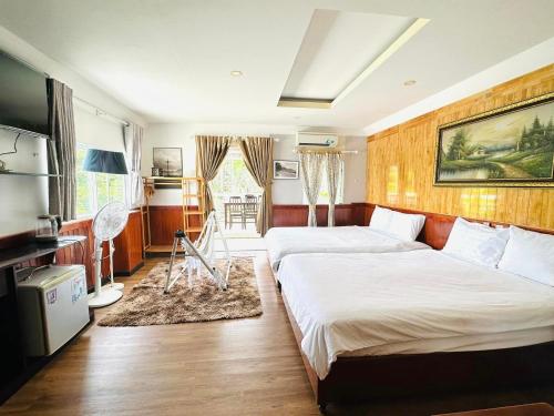 a hotel room with two beds and a television at Con Son Island Hotel in Con Dao