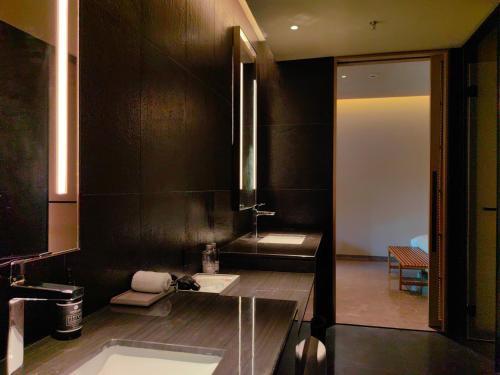a black bathroom with a sink and a tub at Jiangnan House Chaozhou in Chaozhou