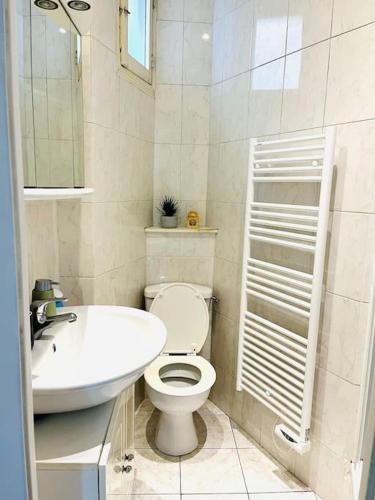 une salle de bain blanche avec des toilettes et un lavabo dans l'établissement Beautiful apartment with balcony, à Paris