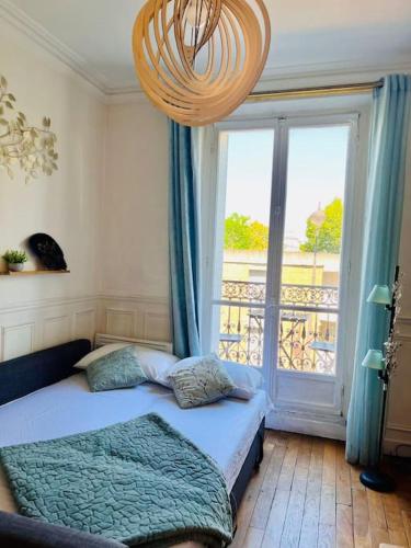 une chambre avec un lit et une grande fenêtre dans l'établissement Beautiful apartment with balcony, à Paris