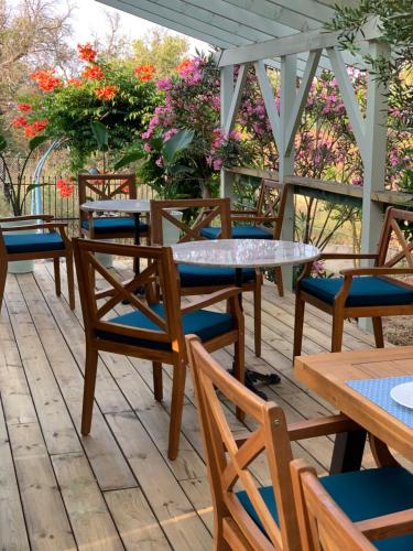 a row of tables and chairs on a deck with flowers at Nisaki Mathraki B&B in Corfu