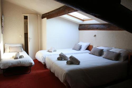 VergèzeにあるLa Passifloreのテディベアが付いたベッド2台が備わる客室です。