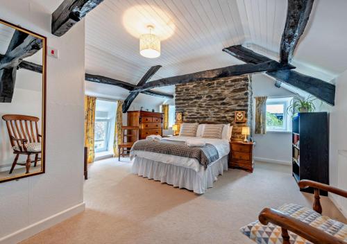 a bedroom with a bed and a stone wall at Old Vicarage Cottage in Llangeler