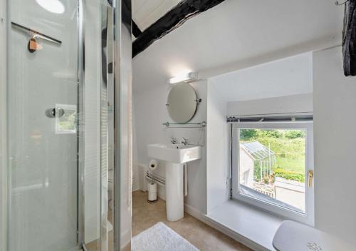 a white bathroom with a sink and a mirror at Old Vicarage Cottage in Llangeler
