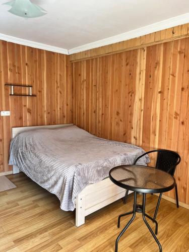 a bedroom with a bed with a table and a chair at Guest House Mari in Ureki