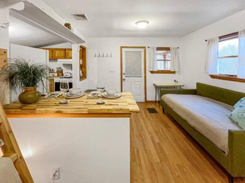 uma cozinha e sala de estar com uma mesa e uma cama em Breezy Hill Eccentric Studio Cottage em Accord