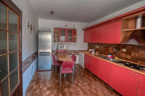 uma cozinha com armários vermelhos e uma mesa em Two Towers em Pančevo