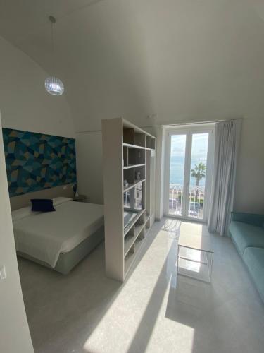 a bedroom with a bed and a large window at La Camera della Nonna 2.0 in Gaeta