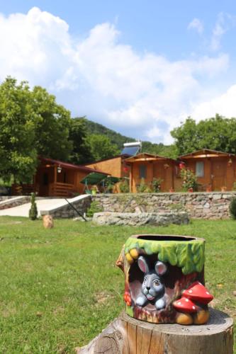 a painting of a cow on top of a tree stump at Cabanutele La Denisa in Dubova