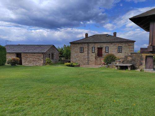 an old stone house with a large yard at Apartamentos rurales Casa Do Cabo in Vega de Logares