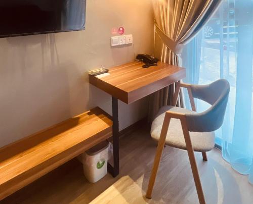 una scrivania e una sedia in una piccola stanza di oxy suites G-01 at Shop House Meisterstadt Pollux Habibie a Batam Center