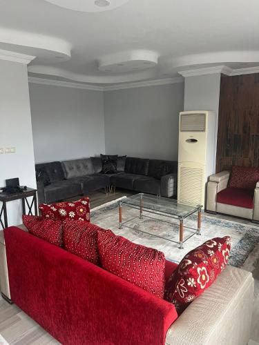 sala de estar con sofá rojo y mesa en Konforlu lüks ev, en Rize