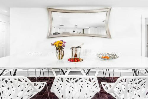 mesa de comedor blanca con espejo y sillas blancas en 5 Room TampaGolfVillas by AmericanVacationliving, en Wesley Chapel