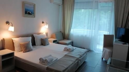 um quarto de hotel com uma cama com toalhas em Hotel Veronika em Kranevo