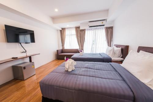 a hotel room with two beds and a tv at Royal Train Garden Resort in Chiang Mai