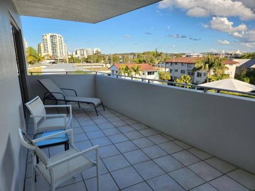 a balcony with chairs and a view of a city at Rovera Apartments in Maroochydore