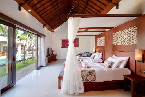 a bedroom with a bed with a wedding veil at Lumbini Luxury Villas and Spa in Jimbaran