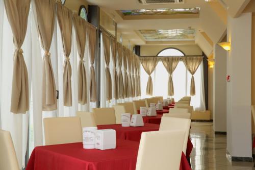 a row of tables and chairs in a room with red table cloth at Hotel Stefan Room & Breakfast in Gatteo a Mare