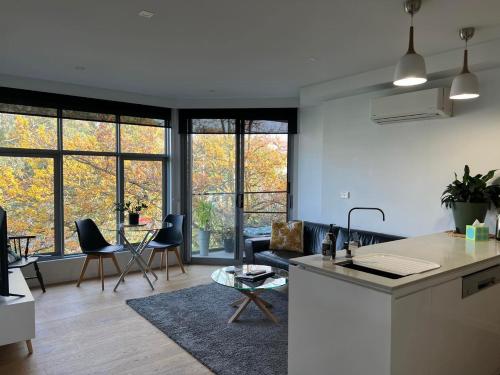 una cucina e un soggiorno con divano e tavolo di Centrepoint Units Heidelberg a Melbourne