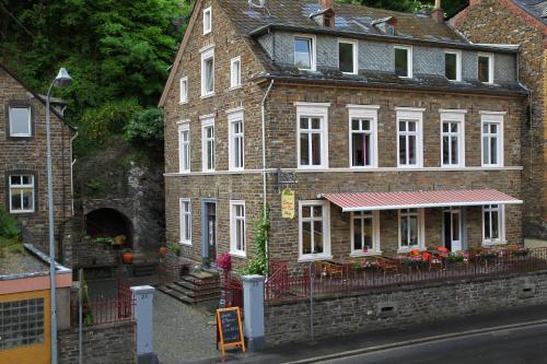 an old brick building with a restaurant in front of it at Hotel Osteria Del Vino Cochem in Cochem