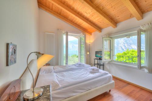 a bedroom with a bed and two windows at Villa Il Paradiso Di Gabri - Happy Rentals in Nago-Torbole
