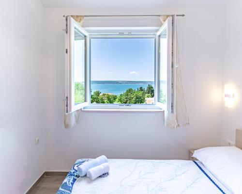 a bedroom with a window with a view of the ocean at Apartments Nina in Maslenica