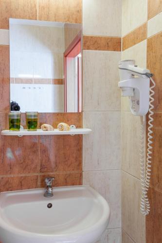 a bathroom with a sink and a mirror at Pensjonat KoGa in Kołobrzeg