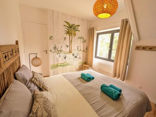 a bedroom with a bed with two green pillows on it at Quartier Saint-Enogat maison de charme proche des plages in Dinard