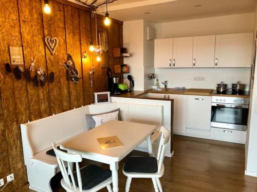 a kitchen with a table and a table and chairs at FeWo Almherzl mit Hallenbad,Sauna,Panoramablick,renoviert in Missen-Wilhams