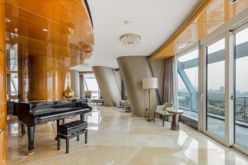 a living room with a piano and chairs at Sheraton Huzhou Taihu Lake Hot Spring Resort & Spa in Huzhou