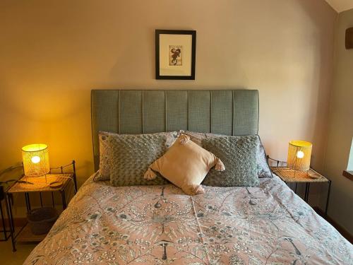 a bedroom with a large bed with two lamps at Honeysuckle Cottage in Longnor