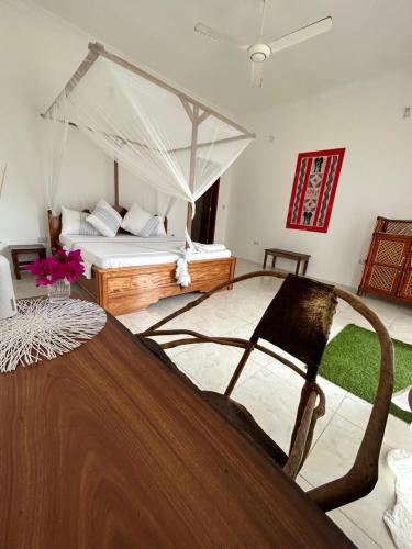 a bedroom with a bed with a canopy at Shamba Lodge in Nungwi