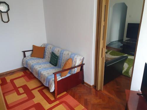 a couch sitting in a living room next to a door at Apartament Codruta in Turda